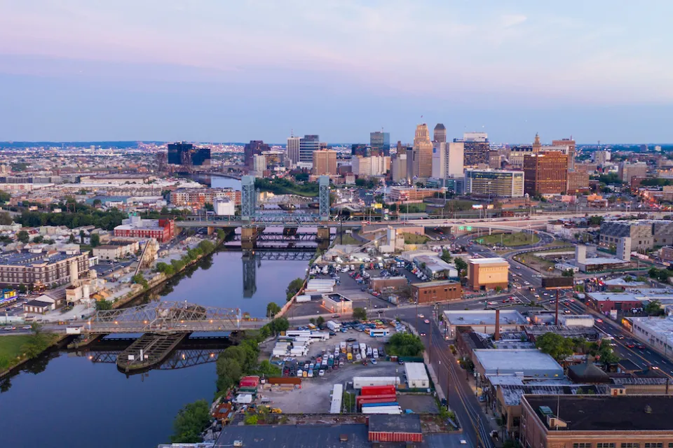 Aerial view of Newwark, New Jersey at sunset with river in foreground.
